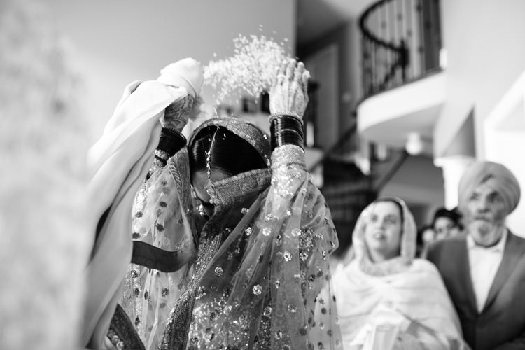 Bride throwing rice at Indian sikh wedding doli